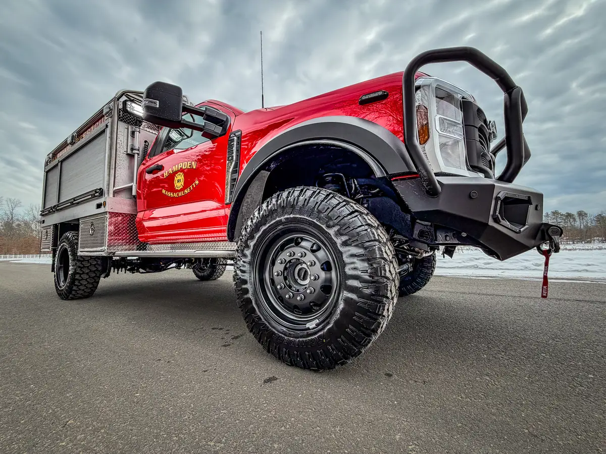 Front corner view with open side panel and exposed front suspension.